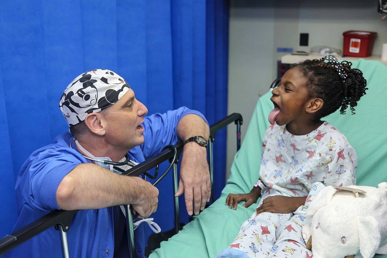 Pediatric patient sticking tongue out with a physician